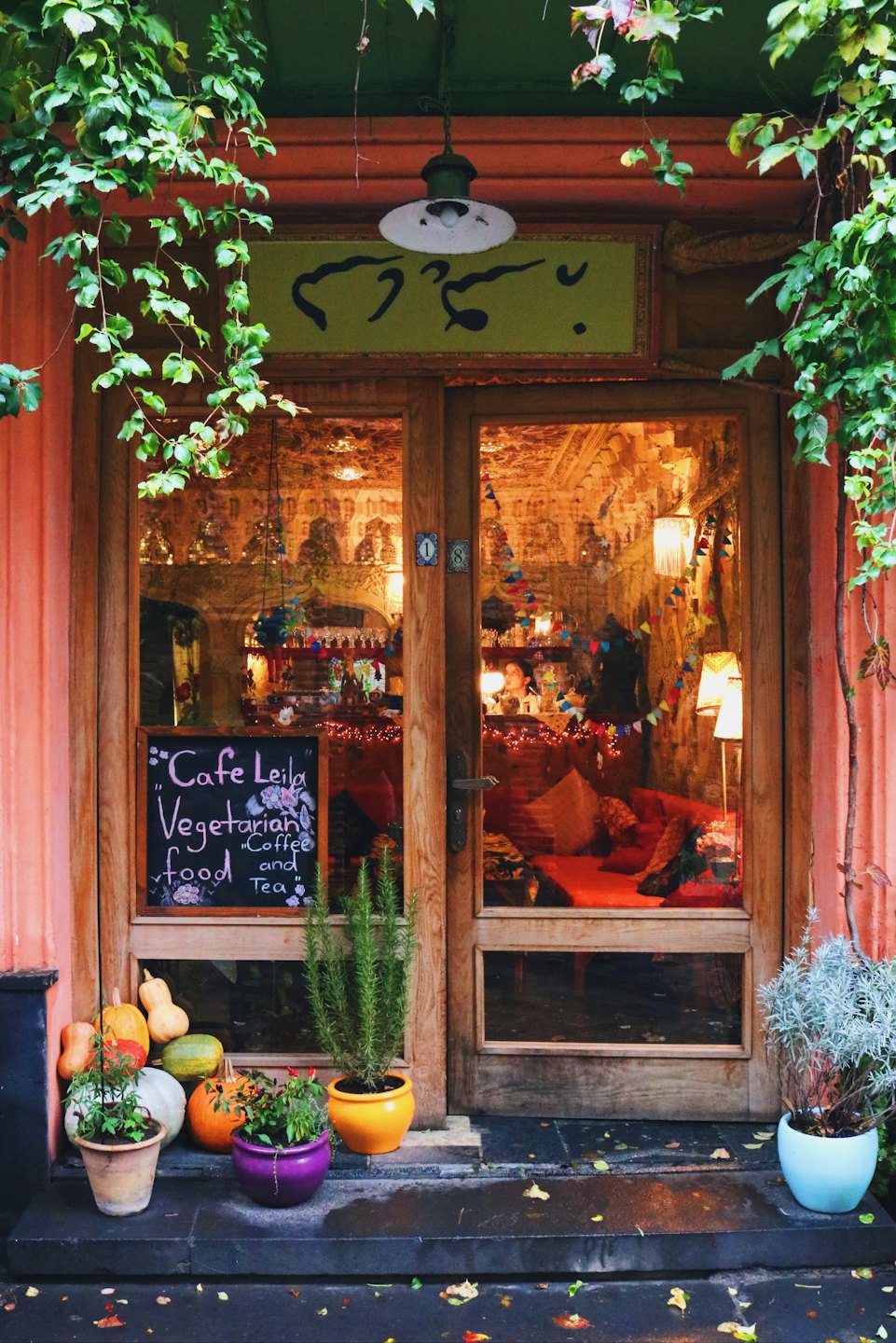 Cafe Leila entrance with wooden doors and vegetarian food sign.